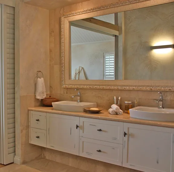 Bathroom with a large framed mirror above a floating timber vanity with two vessel basins